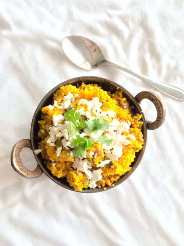 A picture of Comforting Bulgur Wheat Daliya garnished with cottage cheese and coriander and served against a white background.