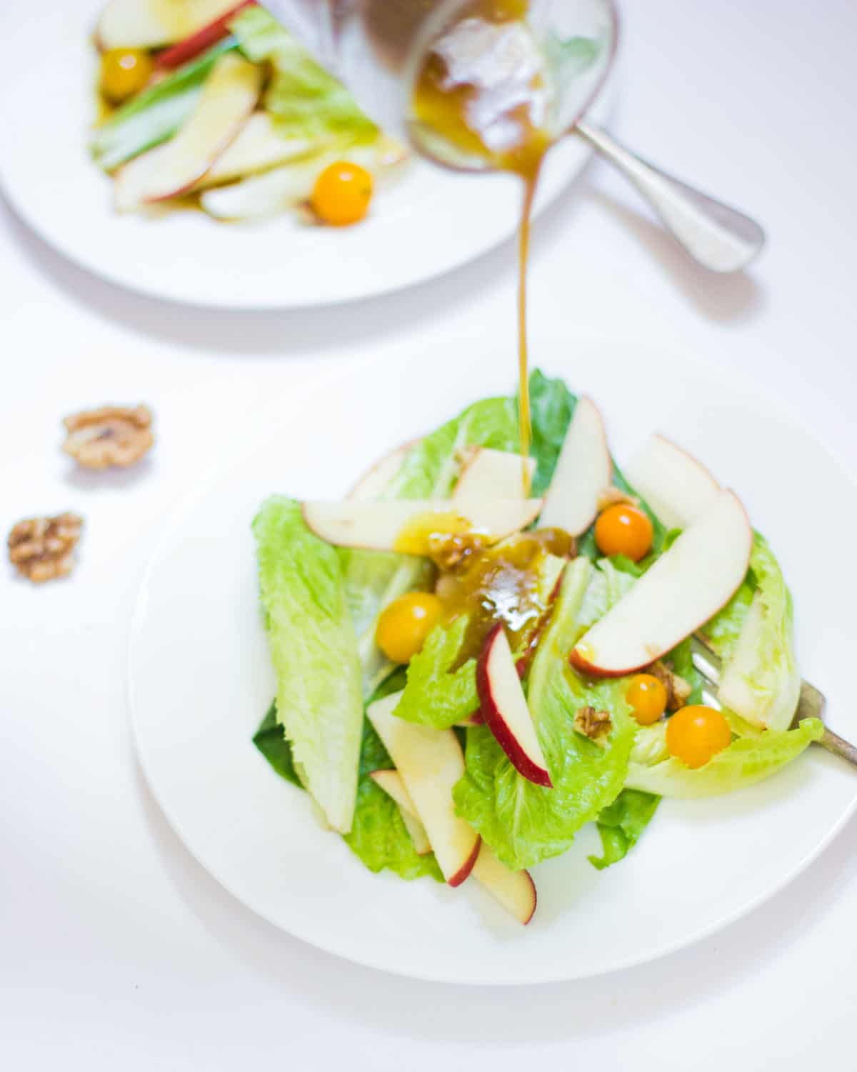 Dressing being poured on the Apple Walnut Summer Salad