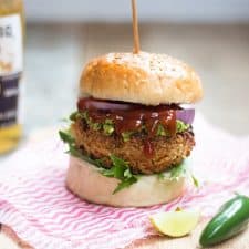 The Fully Loaded Veggie Burger with Avocado Mint Chutney served on a wooden board.