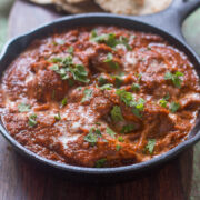 The healthier version of Chicken Tikka Masala garnished with coriander in a pan.