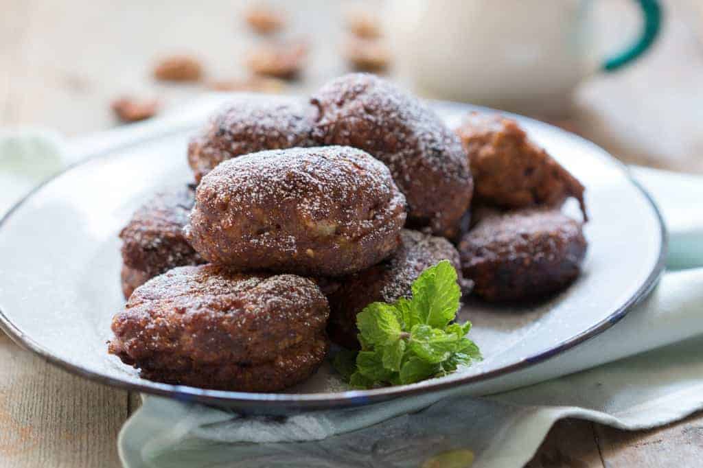 the fritters served in a white plate, garnished with mint leaves