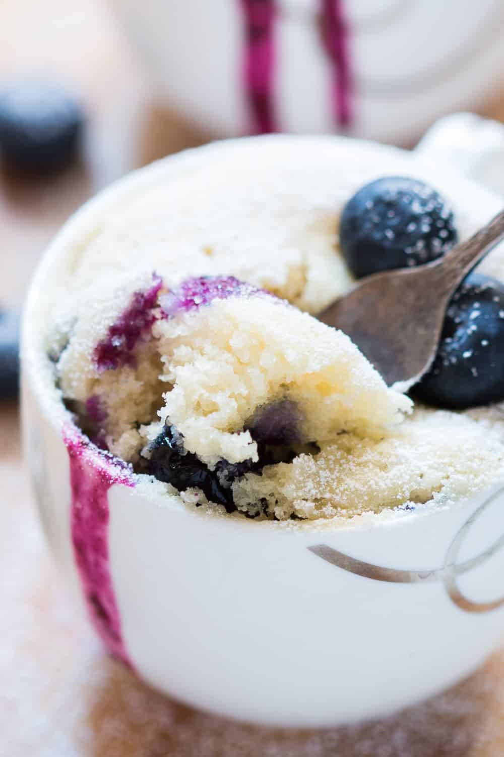 close up bite shot of eggless blueberry microwave mug cake