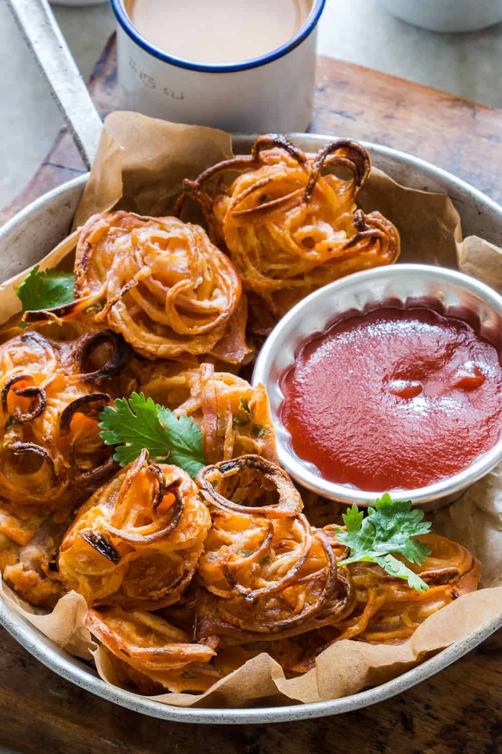 Crispy Baked Onion Pakodas (Fritters) Indians love their pakodas and bhajiyas (fritters) and now there's a guilt-free way to enjoy them with a cup of masala chai. Nobody's ever going to believe these onion pakodas are baked, not fried! Can be made with potato, corn, capsicum and paneer too!