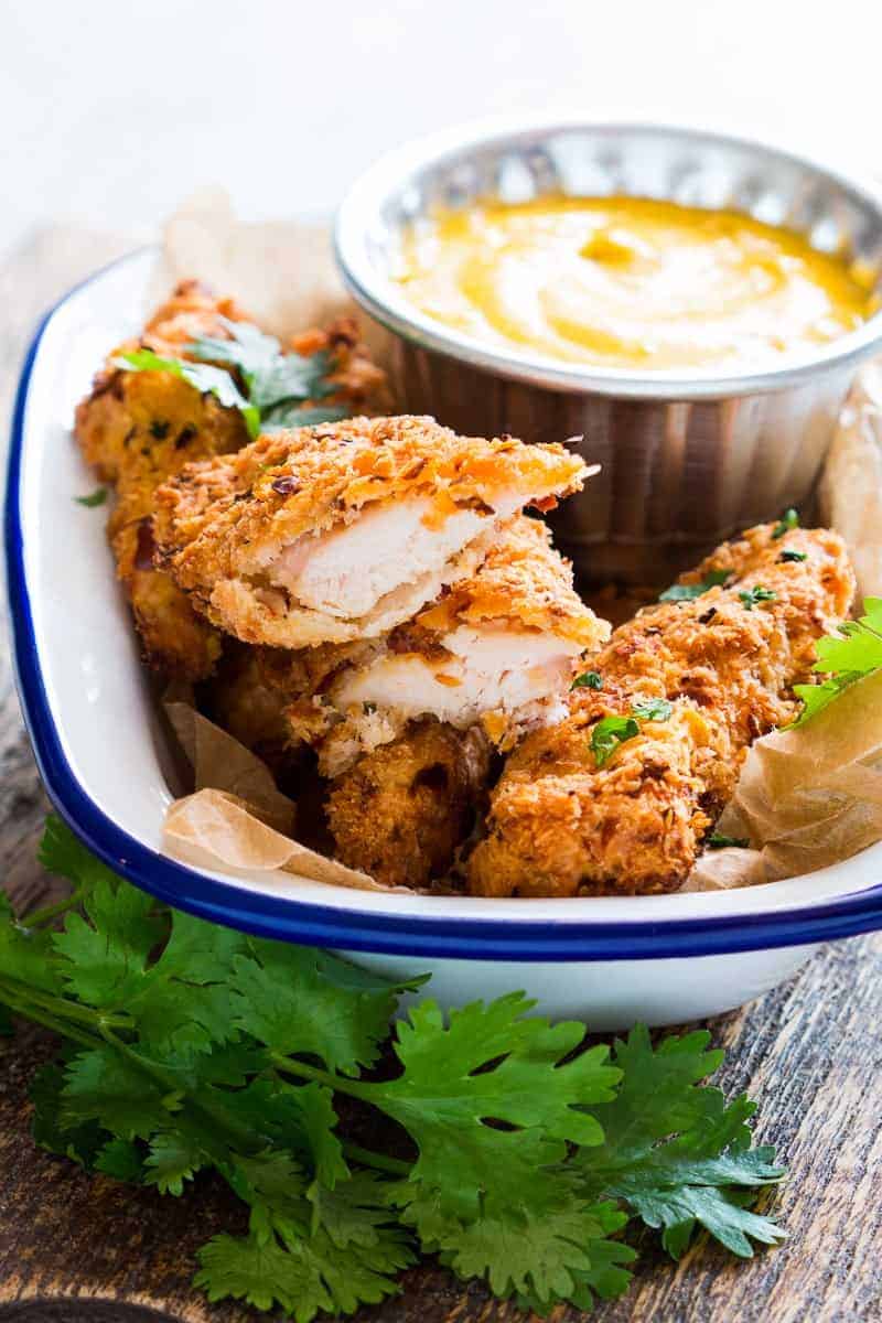 Baked Coconut Chicken Tenders with Mango Mustard Sauce Easy recipe for super crunchy baked coconut crusted chicken tenders which are going to be a favourite at every party with kids and adults alike! Gluten free too.