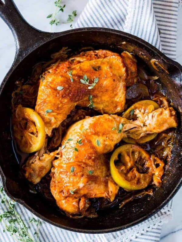 Caramelized Onion Thyme Lemon Chicken Legs in a black pan.