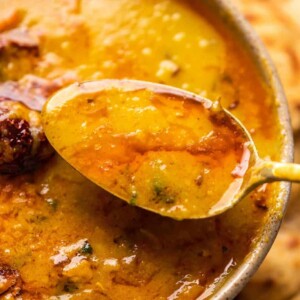 A spoonful of dhaba dal tadka being taken out of the bowl