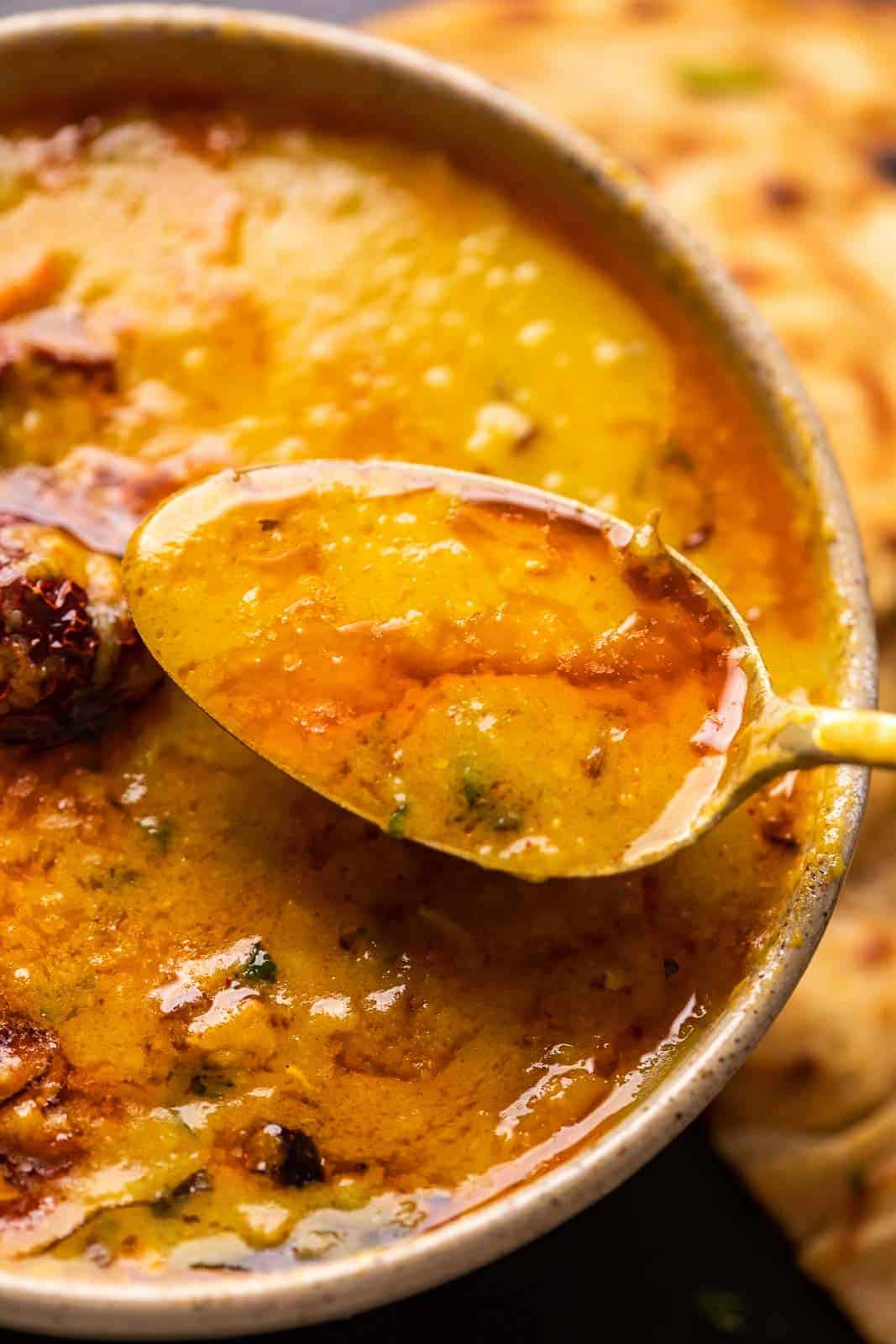 A spoonful of dhaba dal tadka being taken out of the bowl