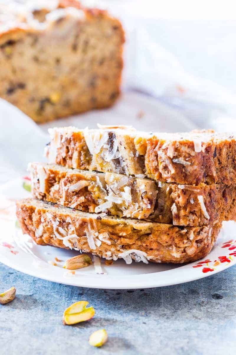 coconut pistachio banana bread slices served on a white plate