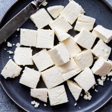 Cubes of paneer on a dark plate