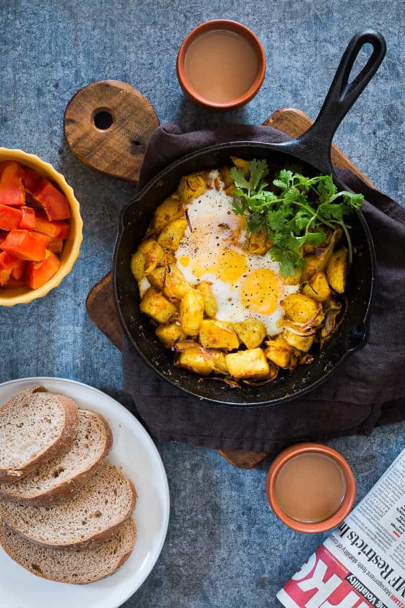 Spiced Indian Potatoes and eggs are cooked in a skillet for a hearty and easy holiday morning breakfast recipe. Perfect for a crowd, kid friendly and gluten free.
