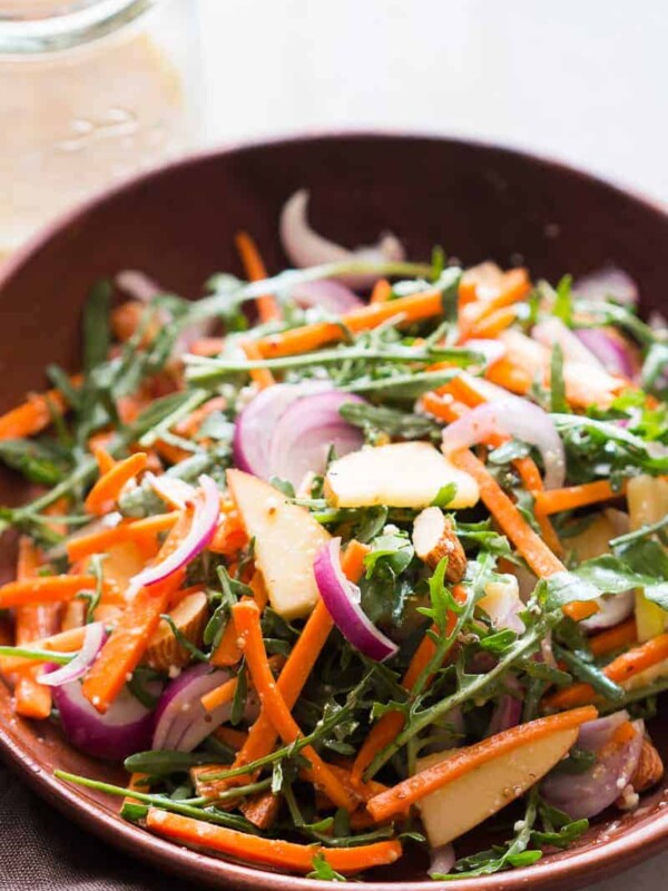 Apple Arugula Almond Salad with Orange Dressing served in a bowl.