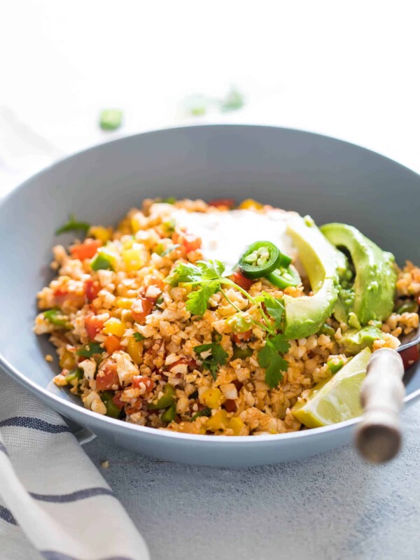 Low Carb Mexican Cauliflower Rice topped with sour cream and avocados.