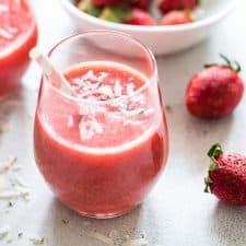 Strawberry Banana Coconut Smoothie garnished with grated coconut and served in a glass with a straw to kick in those tropical vibes!