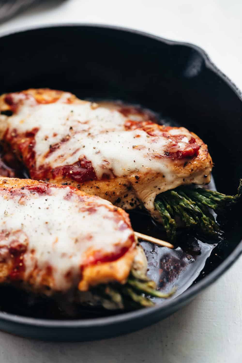 Asparagus stuffed chicken parmesan served on a cast iron pan