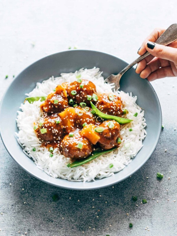 Asian inspired slow cooker teriyaki meatballs with pineapple served with steamed rice in a bowl.