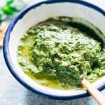 Creamy pesto in a white and blue bowl.