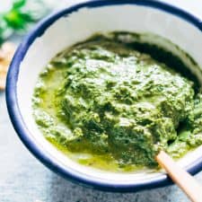 Creamy pesto in a white and blue bowl.