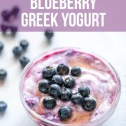 Blueberry greek yogurt served in a bowl with blueberries and honey drizzled on top