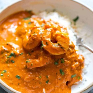 Rice topped with Goan prawn curry and served in a white bowl.