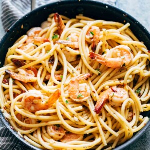 Shrimp Spaghetti Aglio Olio garnished with parsley, parmesan and served in a bowl.