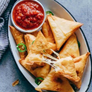 Super cheesy jalapeno three cheese samosa are sure to become a favourite because who can resist gooey stringy cheese stuffed in crispy samosa wrappers! These vegetarian samosas have a filling of mozzarella, cream cheese, smoked cheddar and jalapenos and folding them is really easy too.