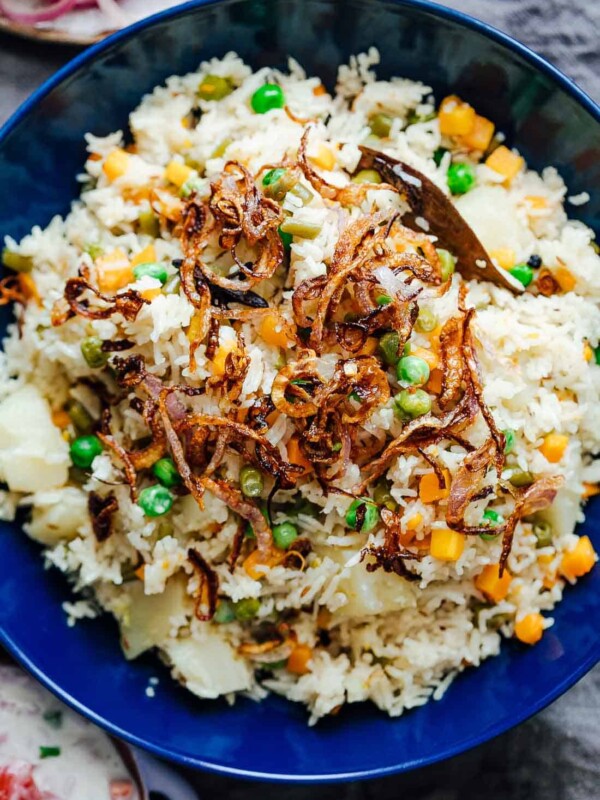 Pressure cooker veg pulao served in a bowl with crispy onions on top