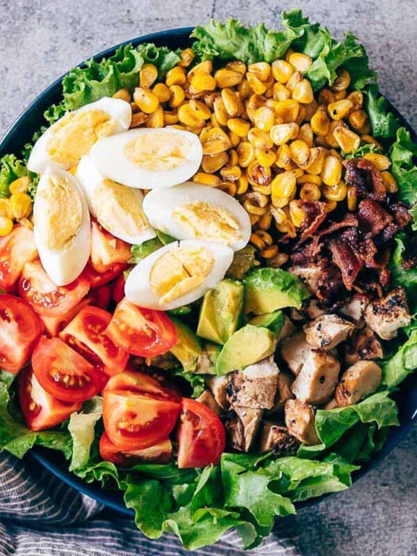 Chicken Cobb Salad served in a bowl - it has lettuce, tomatoes, chicken, bacon, corn and boiled eggs