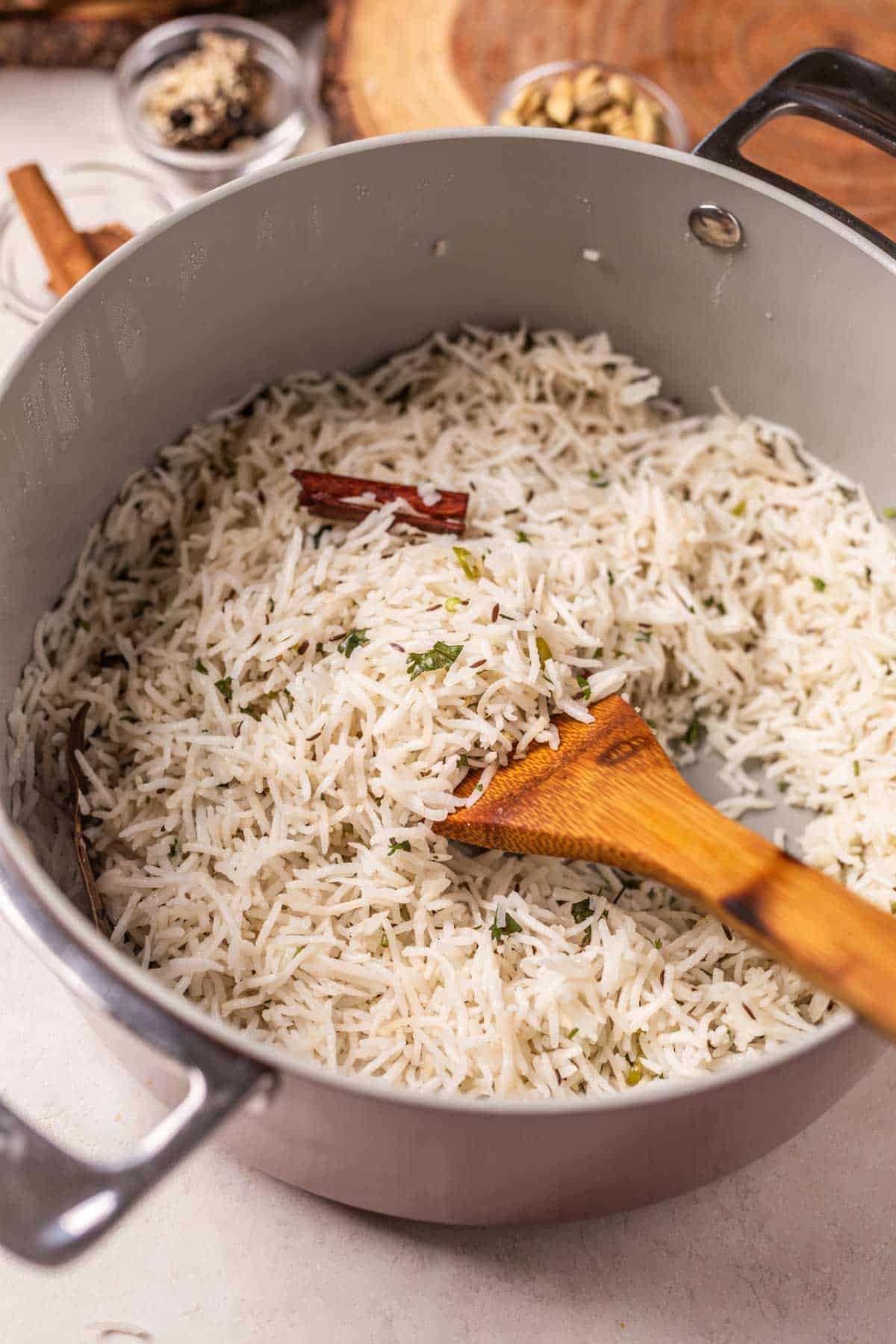 warm jeera rice still in the pan with a wooden ladle, ready to be served