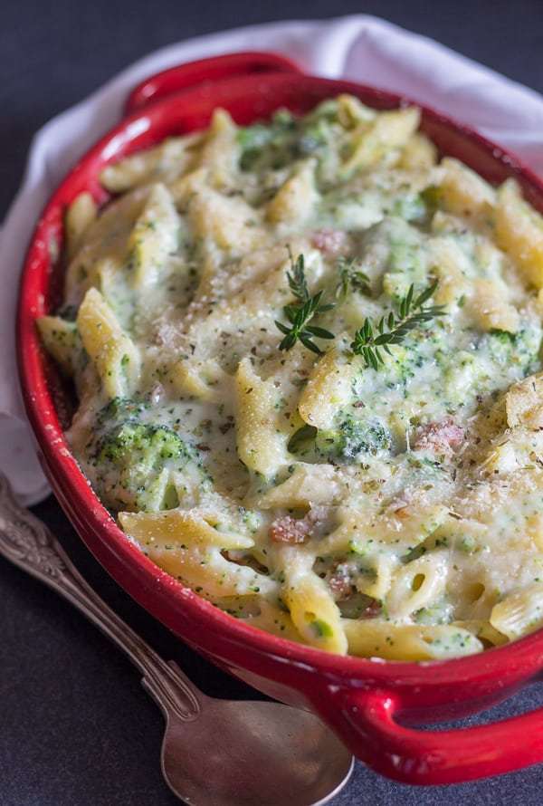 Bacon broccoli pasta casserole served in a red baking casserole