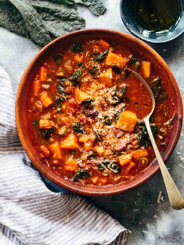 Winter Vegetarian Minestrone Soup served in a bowl topped with parmesan and olive oil