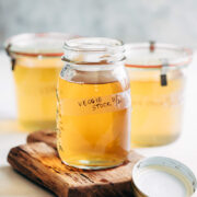 Homemade vegetable stock strained into a canning jar
