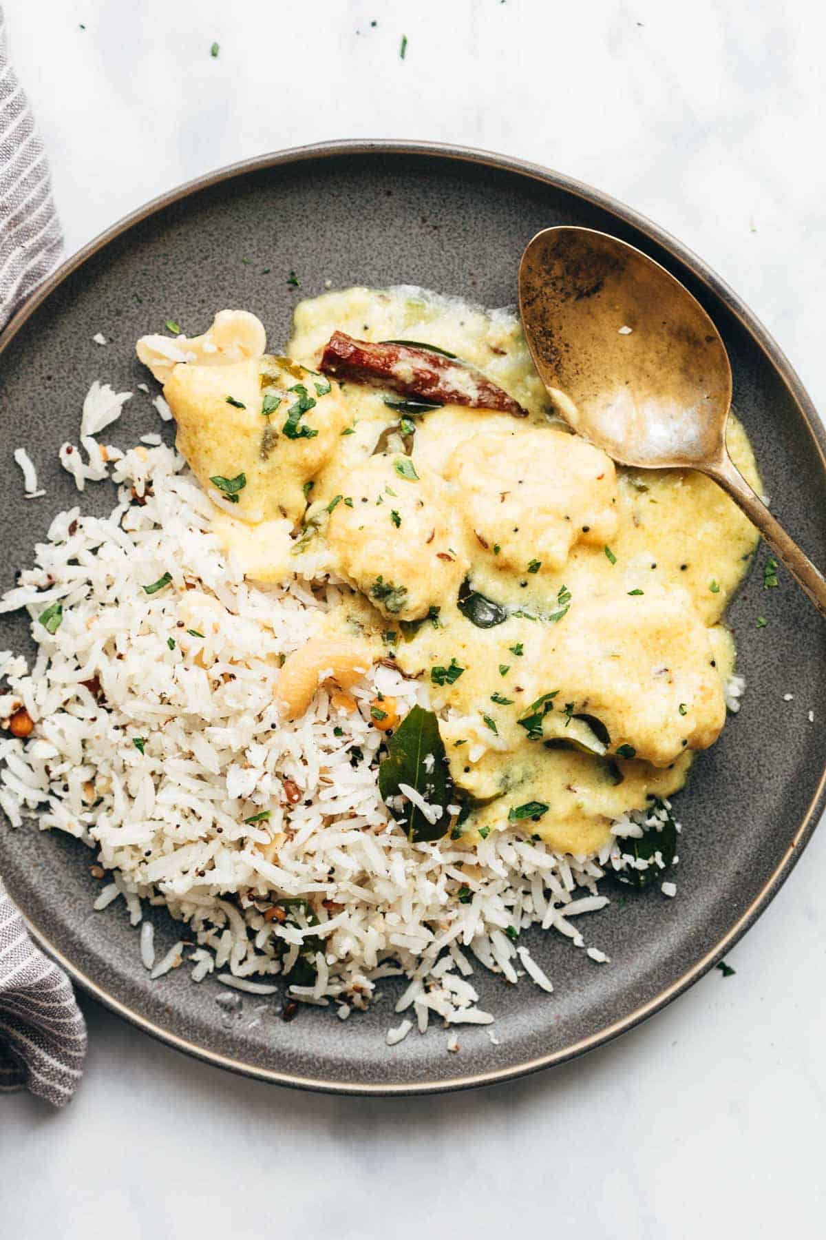 Coconut rice served with kadhi on a plate