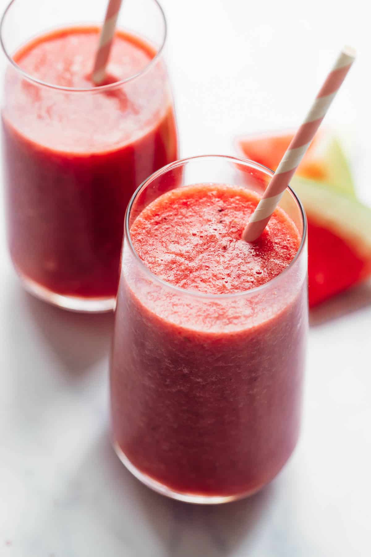 Two glasses of watermelon lime smoothie with paper straws