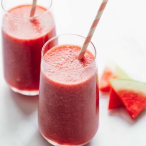 Two glasses of watermelon lime smoothie with paper straws