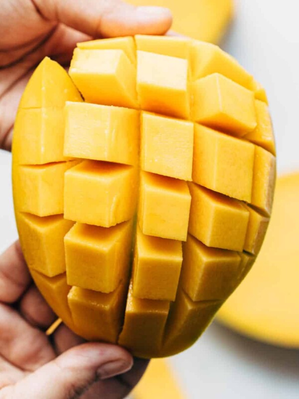 A peeled mango cut into dices by making horizontal and vertical cuts.