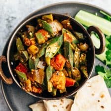 Overhead shot of bhindi masala served with chapatis and salad