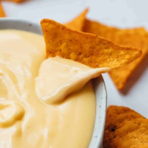 Nacho dipped in spicy nacho cheese sauce