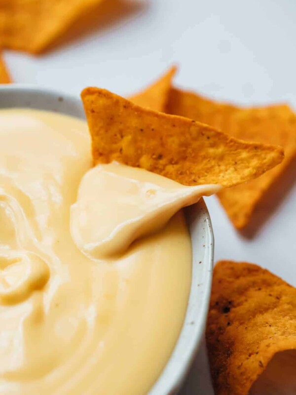 Nacho dipped in spicy nacho cheese sauce