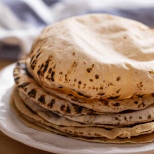 Soft puffy rotis stacked on a plate