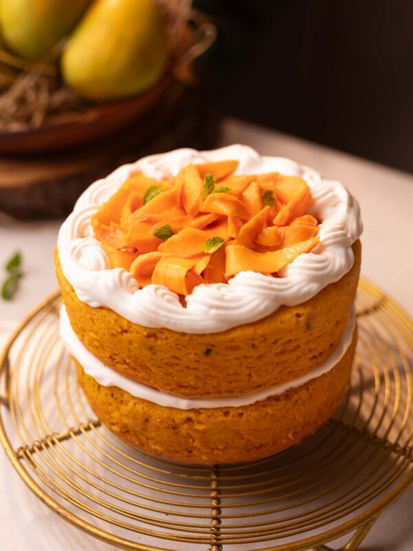 an image of a whole eggless mango cake placed on a wire rack
