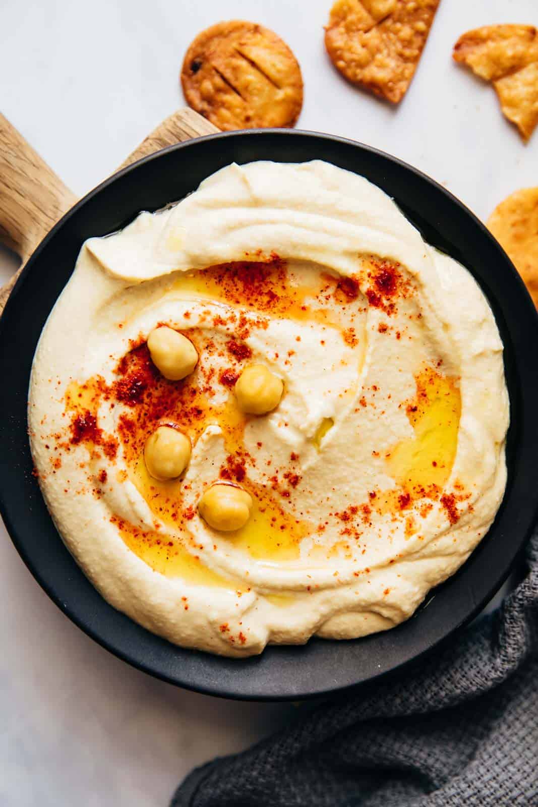 Hummus served on a plate with fried pita, olive oil and chickpeas