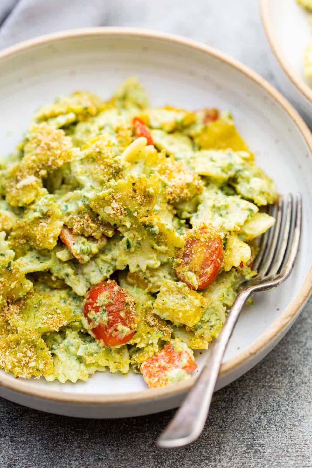 Closeup of pasta in jalapeno pesto served in a pasta bowl with a fork