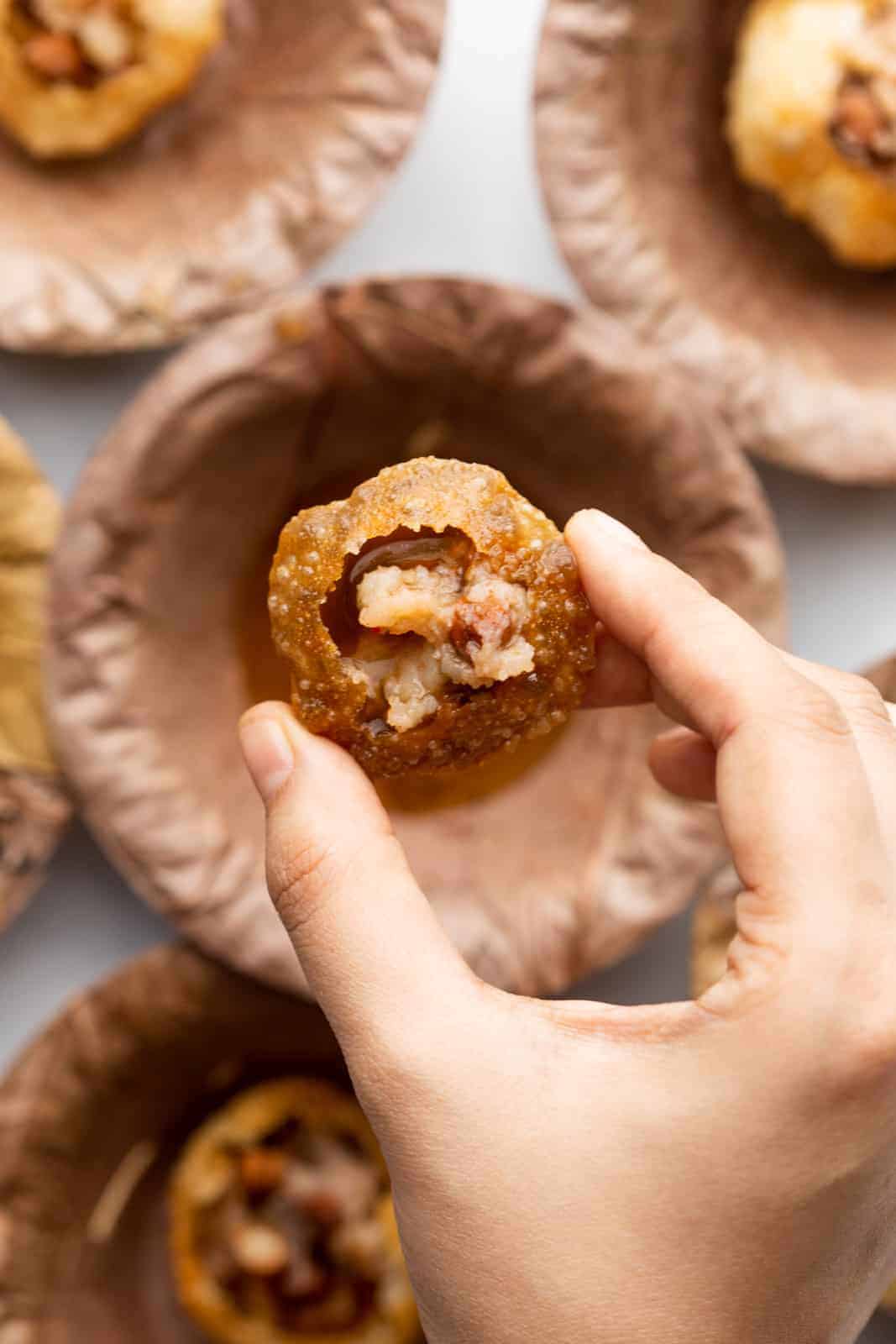 Closeup of a hand picking up pani puri