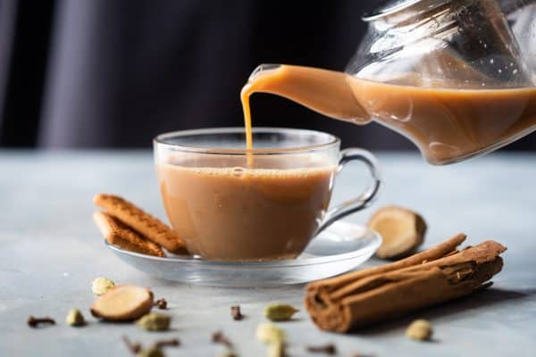Ginger Chai being poured into a cup from a kettle