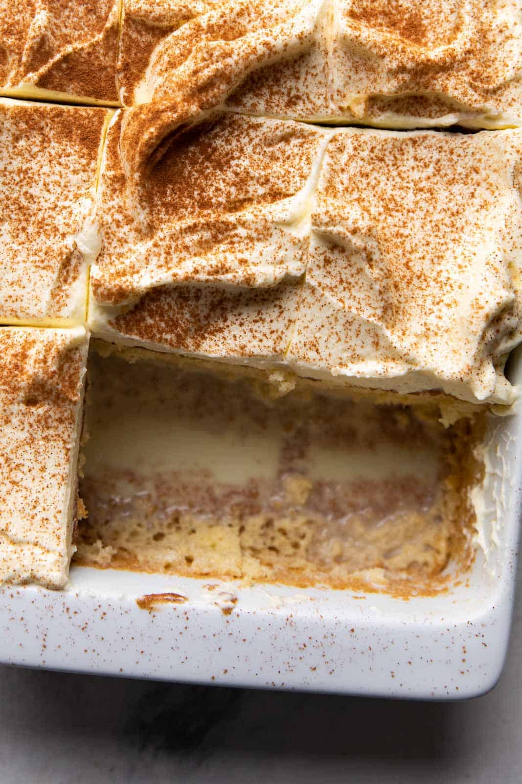 Closeup of two slices of eggnog tres leches taken out for serving
