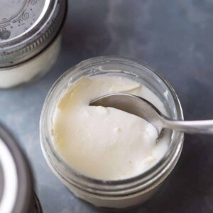 A spoon cutting into the yogurt to show the thick consistency of yogurt