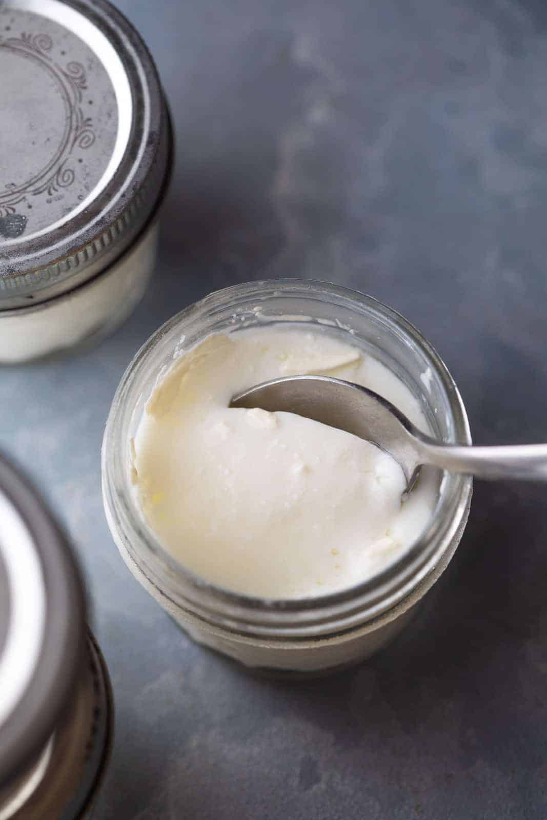 A spoon cutting into the yogurt to show the thick consistency of yogurt
