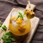 roasted pineapple moscow mule is a stemless wine glass with sprigs of mint
