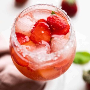 Strawberry Pepper Gin and Tonic served in a short stemmed glass with sugar on the rim