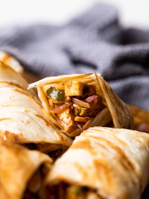 Paneer kathi roll cut into pieces and stacked on top of the other